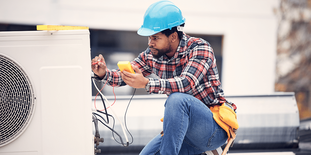 Young HVAC technician performs maintenance on a commercial HVAC system.