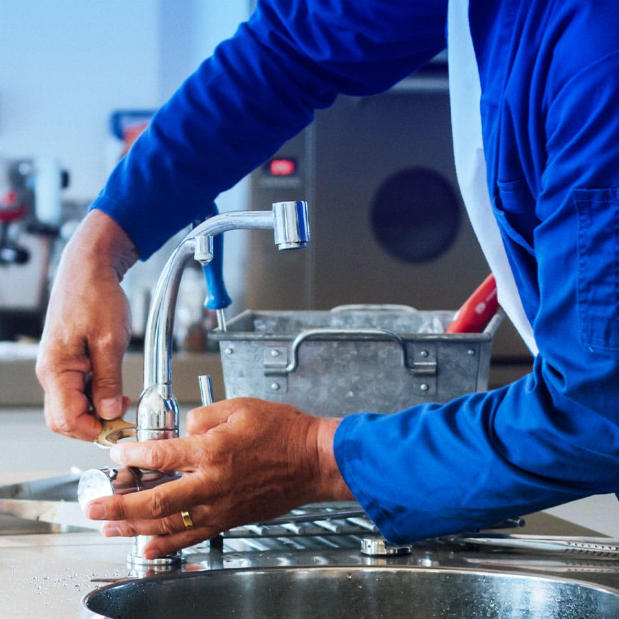 Plumbing 24/7 Emergency Service Plumber repairing a broken faucet in home.