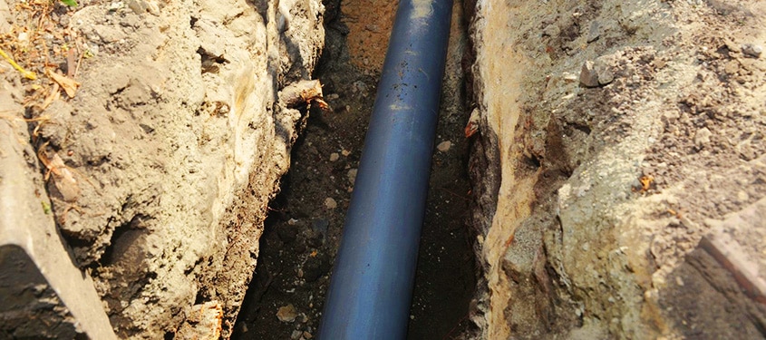 Trenchless Pipe Repair Image of a sewer pipe inside a freshly dug trench as part of a replacement service.